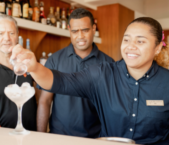 students serving cocktails at bar 